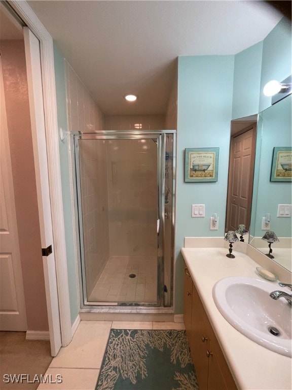 bathroom featuring vanity, tile patterned floors, and a shower with shower door