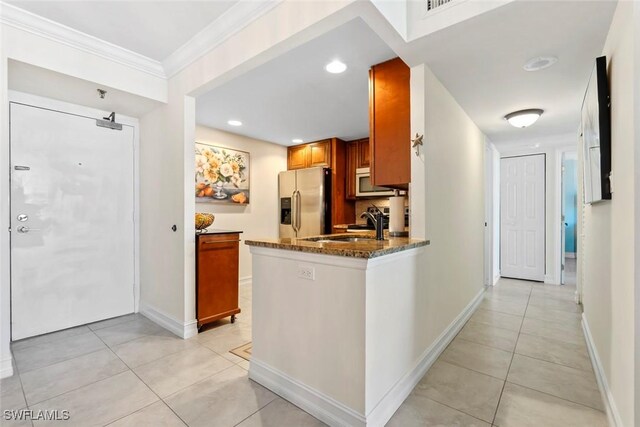 380 Seaview Ct Unit 1808, Marco Island, FL 34145 - kitchen featuring stainless steel fridge with ice dispenser, light tile patterned floors, brown cabinetry, dark stone countertops, and crown molding