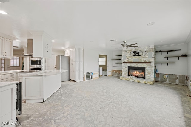 unfurnished living room with crown molding, a stone fireplace, a healthy amount of sunlight, and ceiling fan