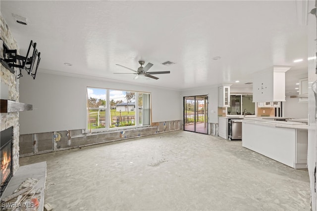 unfurnished living room with ornamental molding, a fireplace, and ceiling fan