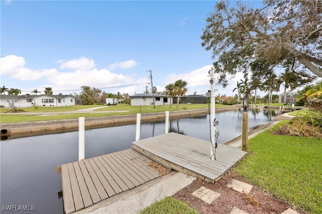 dock area featuring a water view and a yard