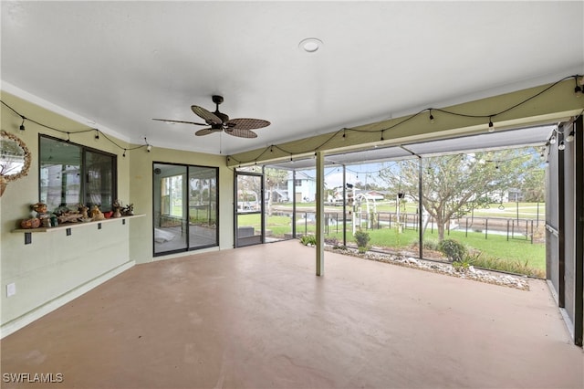 unfurnished sunroom featuring ceiling fan