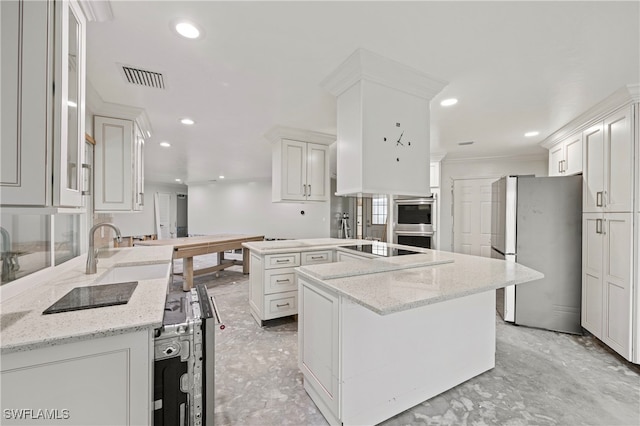 kitchen featuring white cabinetry, light stone counters, stainless steel appliances, and kitchen peninsula