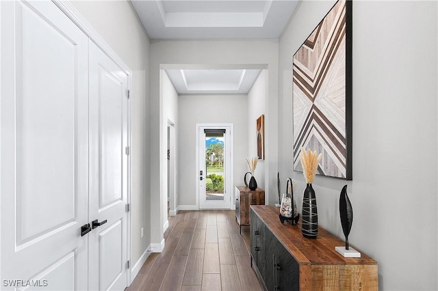 doorway to outside featuring a tray ceiling