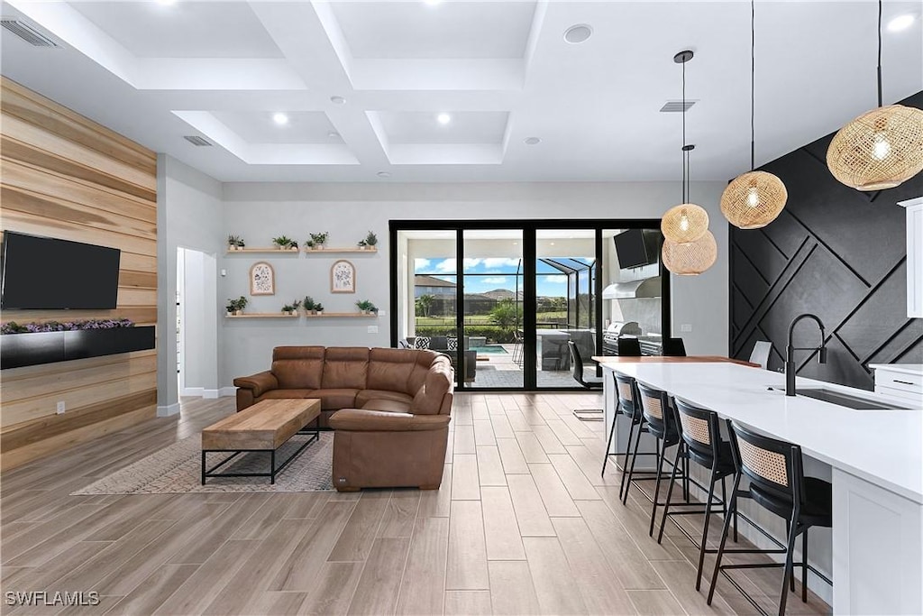 living room featuring sink, beamed ceiling, and coffered ceiling