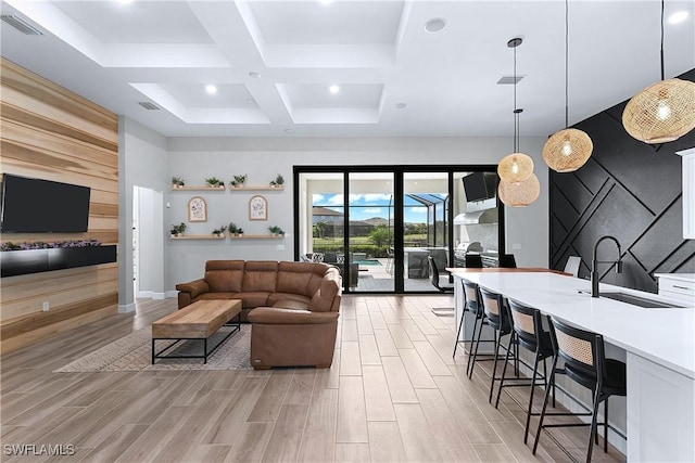 living room featuring sink, beamed ceiling, and coffered ceiling