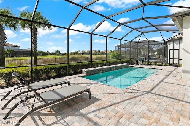 view of swimming pool featuring a lanai and a patio area