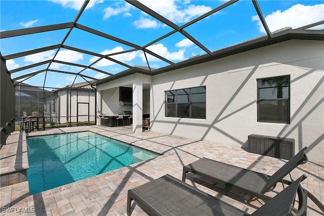 view of swimming pool featuring glass enclosure and a patio area