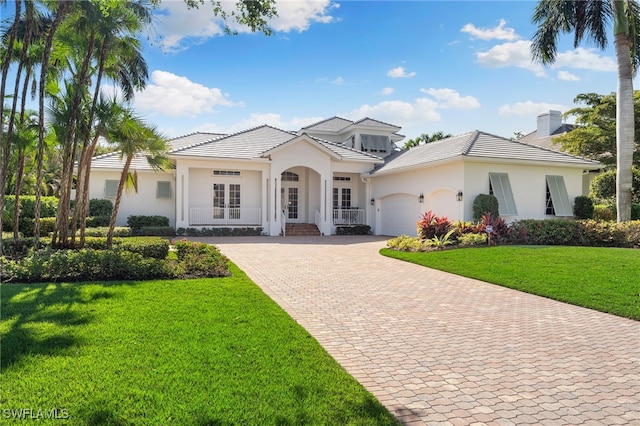 view of front of house featuring french doors, a garage, and a front lawn