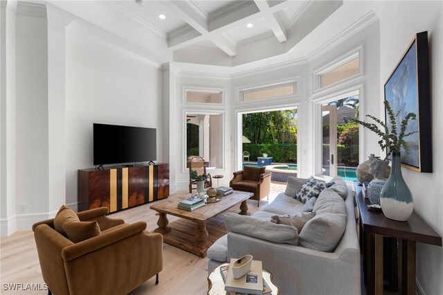 living room featuring coffered ceiling, crown molding, a towering ceiling, beam ceiling, and light hardwood / wood-style floors