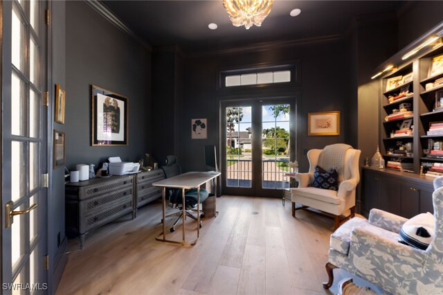 living area with crown molding, french doors, a notable chandelier, and hardwood / wood-style flooring