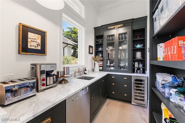 bar with light wood-type flooring, stainless steel dishwasher, ornamental molding, beverage cooler, and sink