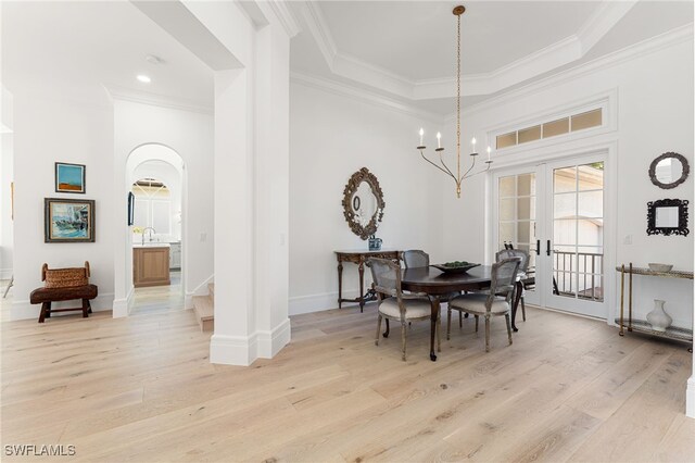 dining area featuring a chandelier, sink, ornamental molding, and light wood-type flooring