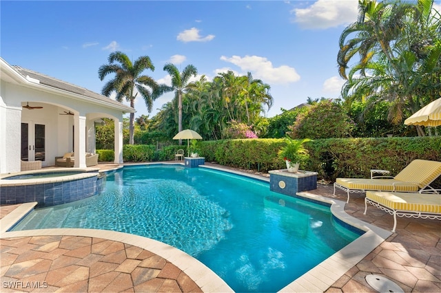 view of pool with a patio area, an in ground hot tub, and french doors