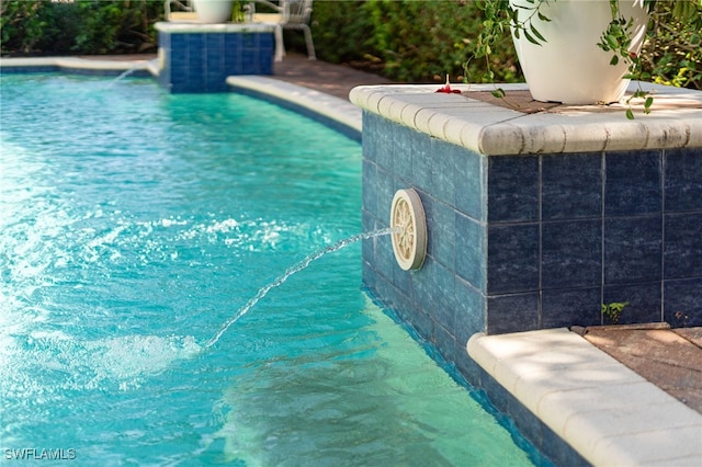 view of swimming pool with pool water feature