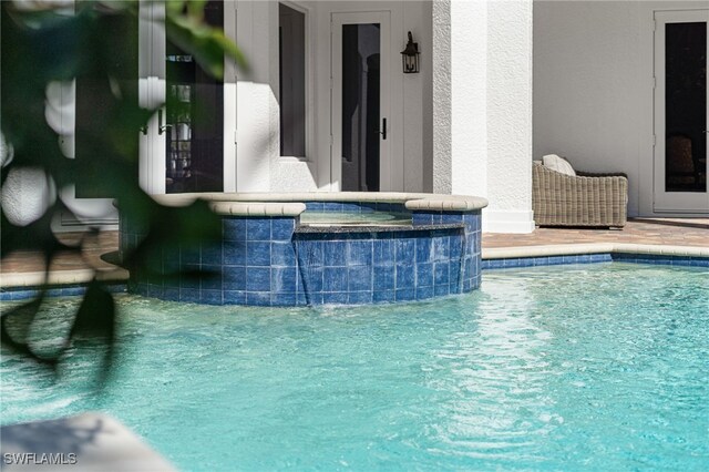 view of swimming pool featuring an in ground hot tub