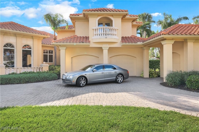 mediterranean / spanish-style house featuring a garage and a balcony