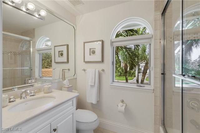 bathroom featuring vanity, an enclosed shower, and toilet