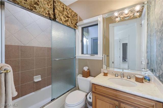 full bathroom featuring vanity, toilet, and combined bath / shower with glass door