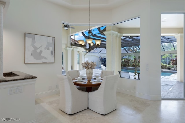 dining room featuring ceiling fan with notable chandelier and ornate columns