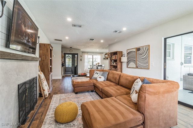 living room with a textured ceiling and hardwood / wood-style flooring