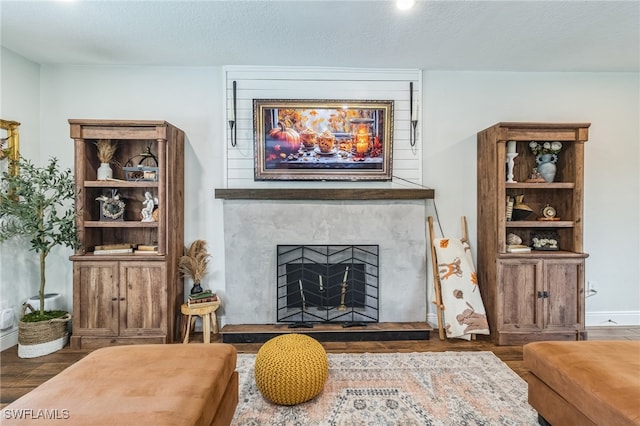 living room featuring a textured ceiling and dark hardwood / wood-style floors