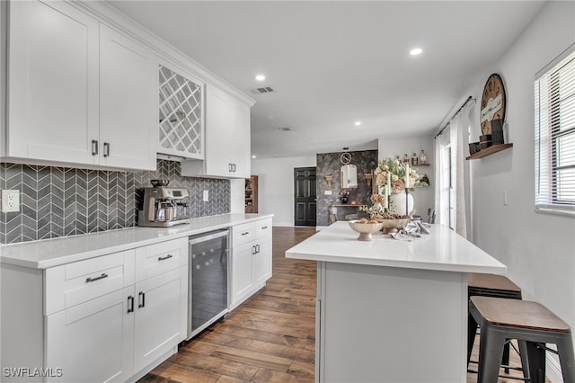 kitchen featuring a center island, dark hardwood / wood-style floors, white cabinetry, and beverage cooler