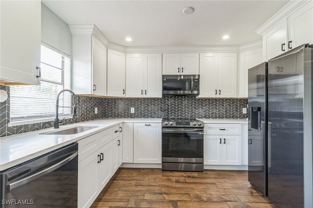 kitchen featuring tasteful backsplash, white cabinetry, dark hardwood / wood-style floors, sink, and stainless steel appliances