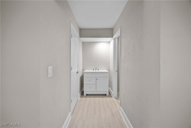 corridor featuring light hardwood / wood-style floors and sink