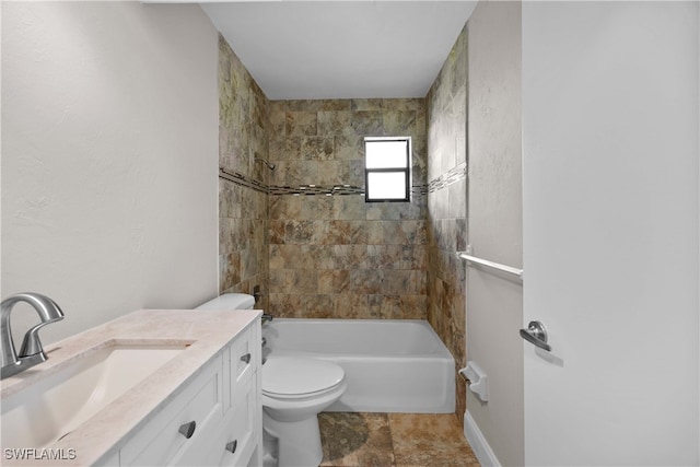 full bathroom featuring tiled shower / bath, vanity, and toilet