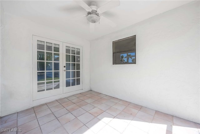 spare room with french doors, light tile patterned floors, and ceiling fan