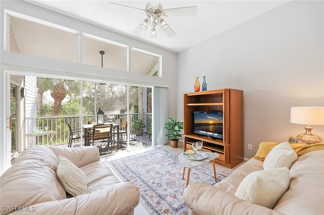 living room with ceiling fan, vaulted ceiling, and light tile patterned floors