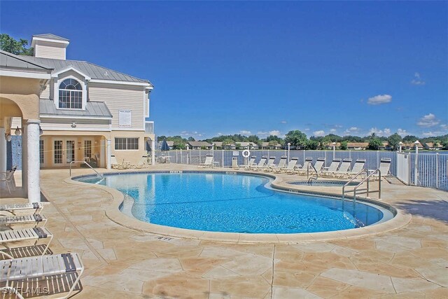 view of swimming pool featuring a patio and french doors