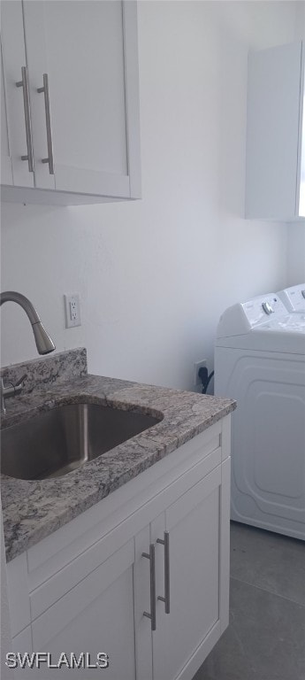 clothes washing area with cabinets, sink, and washing machine and dryer