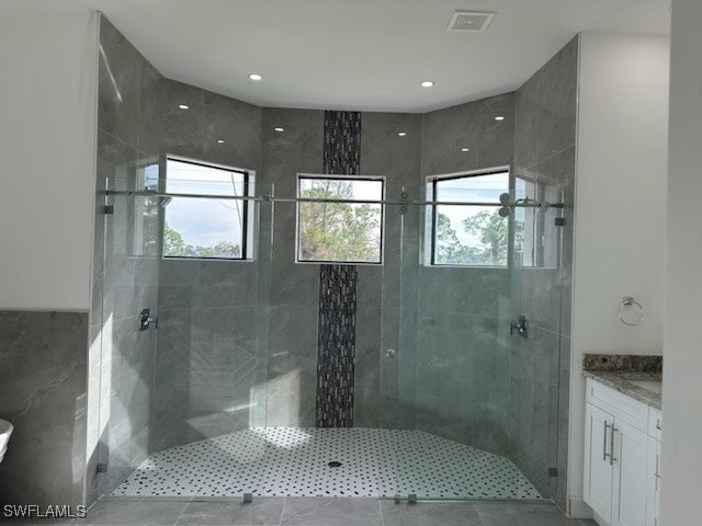 bathroom featuring vanity, tile patterned floors, and a shower with door