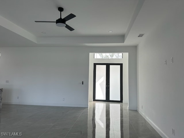 interior space featuring ceiling fan and a raised ceiling