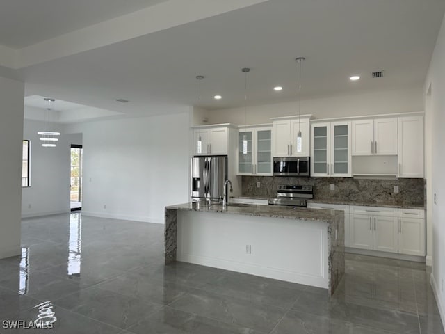 kitchen with white cabinetry, appliances with stainless steel finishes, pendant lighting, and decorative backsplash