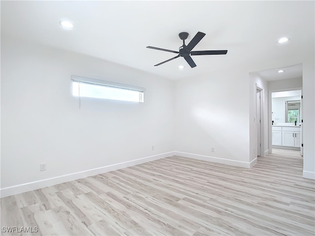 spare room with light hardwood / wood-style flooring, a wealth of natural light, and ceiling fan