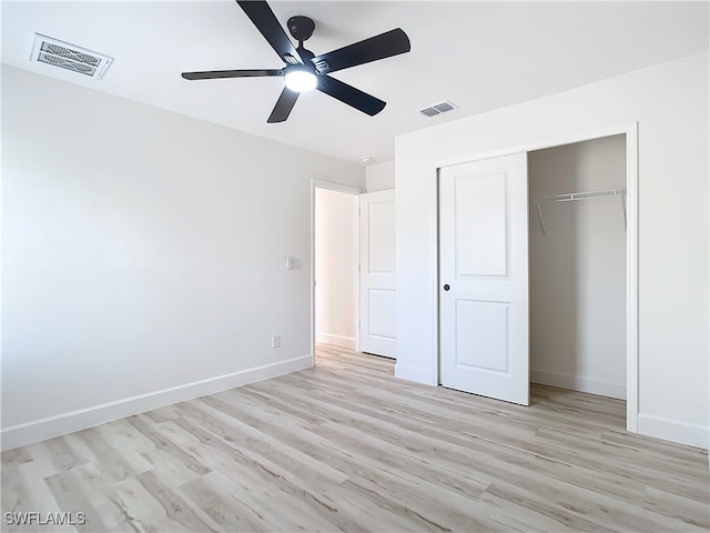 unfurnished bedroom with ceiling fan, light wood-type flooring, and a closet