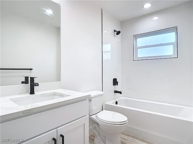 full bathroom with hardwood / wood-style flooring, vanity, toilet, and washtub / shower combination