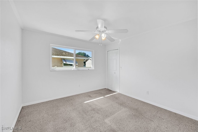 empty room with ceiling fan, ornamental molding, and carpet floors