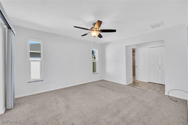 carpeted spare room with plenty of natural light and ceiling fan