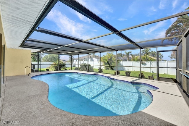 view of pool featuring a lawn, a patio, and glass enclosure