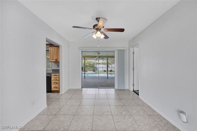 spare room with ceiling fan and light tile patterned floors