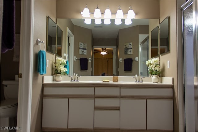 bathroom featuring toilet, an enclosed shower, vanity, and ceiling fan