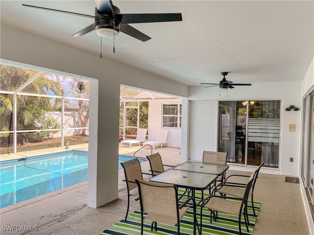 exterior space featuring a patio area, glass enclosure, and ceiling fan