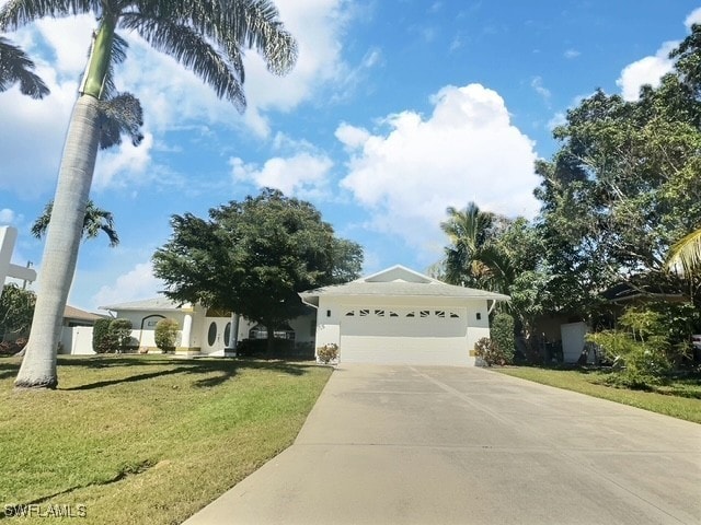 ranch-style house featuring a front yard, concrete driveway, and a garage