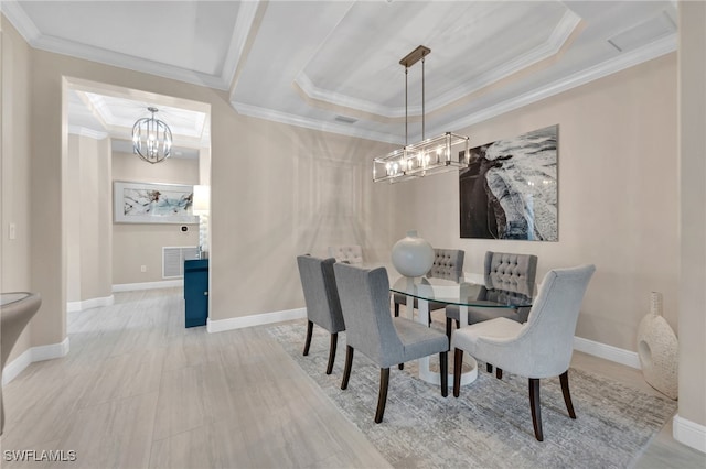 dining area with ornamental molding and a raised ceiling