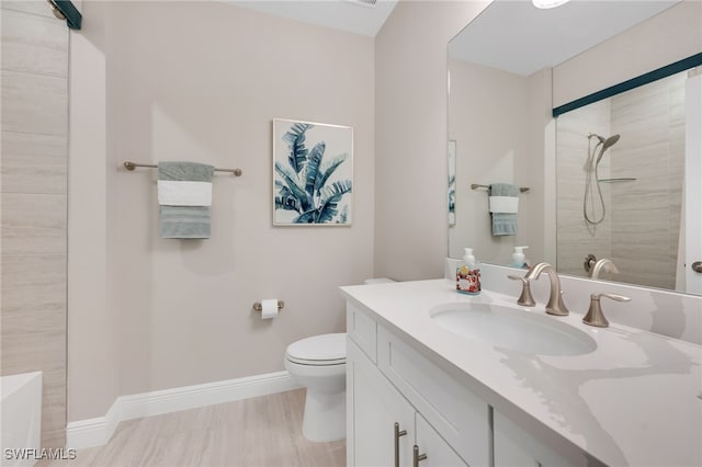 bathroom with toilet, hardwood / wood-style floors, vanity, and a tile shower