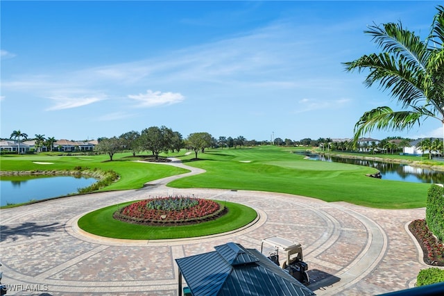 view of property's community with a water view and a lawn